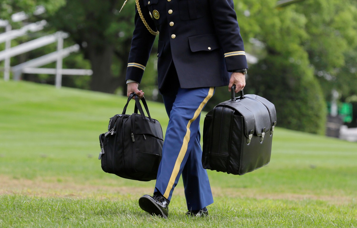 A White House military aide and member of the U.S. Army carries the brief case containing nuclear weapons codes as U.S. President Barack Obama returns to the White House in Washington
