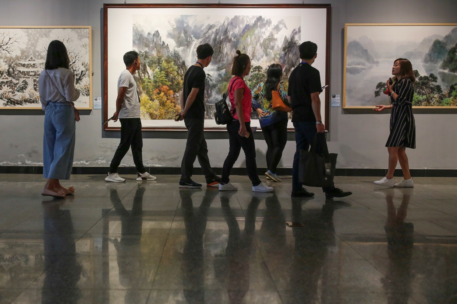 Visitors look at works by North Korean artists at the Mansudae Art Museum in Beijing