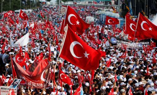 People wave Turkey's national flags as they attend a ceremony marking the first anniversary of the attempted coup at the Bosphorus Bridge in Istanbul, Turkey July 15, 2017. REUTERS/Murad Sezer - RC11D232ECA0