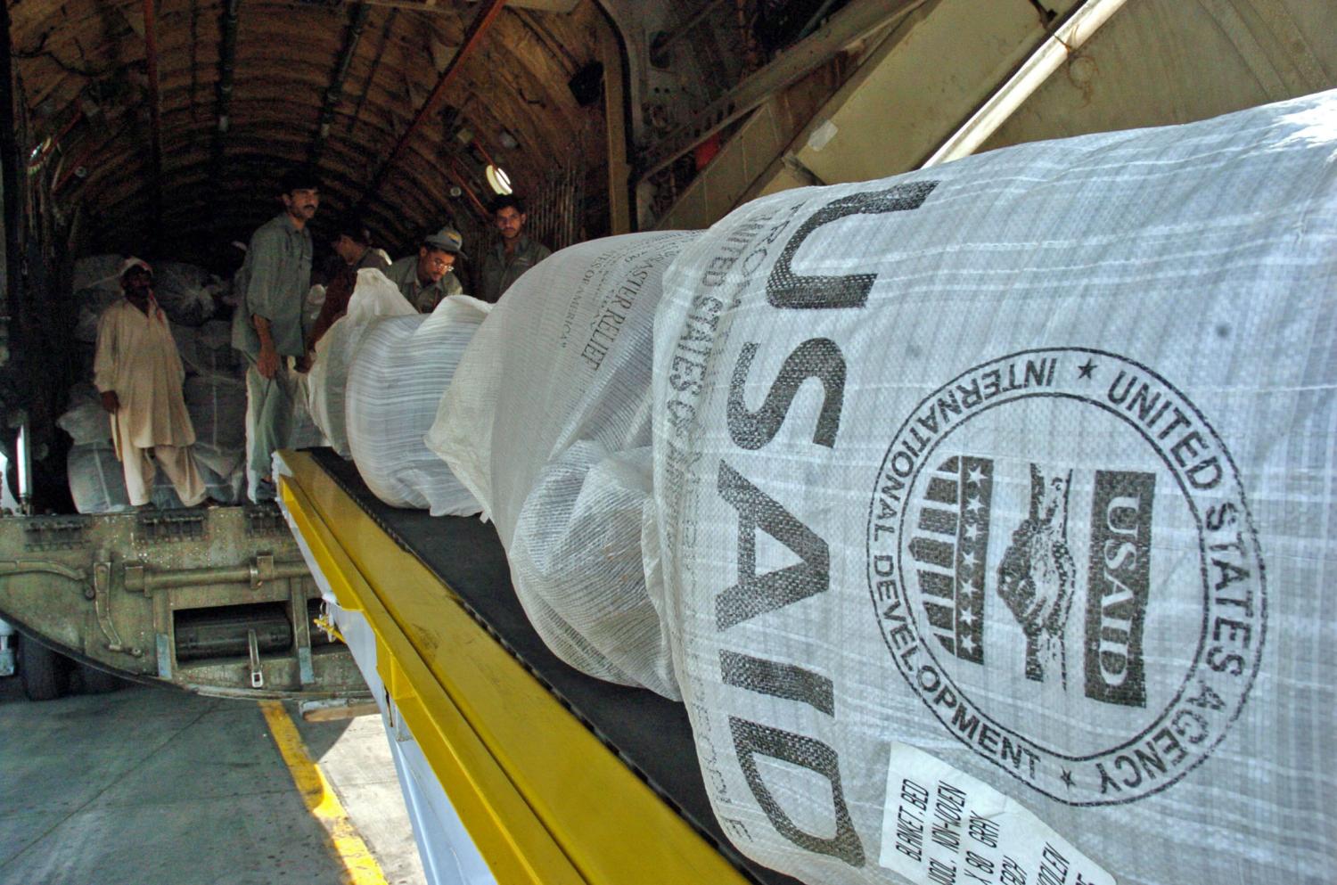 Pakistani workers unloads relief goods sent by the U.S. Agency for International Development (USAID) at a military base in Rawalpindi October 10, 2005. Donor nations rushed doctors, helicopters, food, tents and sniffer dogs to help the victims of Pakistan's devastating earthquake on Monday as the death toll topped 20,000. Aid agencies said more than 120,000 people, many of them children, were in urgent need of shelter and up to four million could be left homeless by the 7.6 magnitude earthquake which wrecked buildings and villages in Pakistan's northern mountains. REUTERS/Mian Khursheed - RP2DSFHVAJAE
