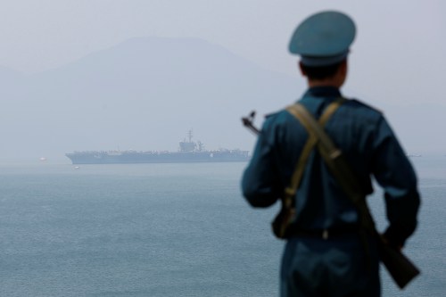 A Vietnamese soldier keeps watch in front of U.S. aircraft carrier USS Carl Vinson after its arrival at a port in Danang, Vietnam March 5, 2018. REUTERS/Kham - RC1CCE413490