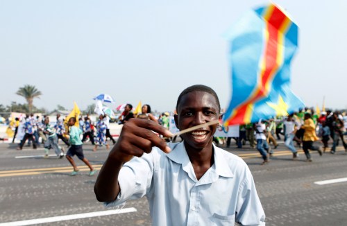 A man waves a Congolese flag during a civil and military parade marking the 50th anniversary of the independence of the Democratic Republic of Congo in Kinshasa June 30, 2010. REUTERS/Sebastien Pirlet (DEMOCRATIC REPUBLIC OF CONGO - Tags: POLITICS ANNIVERSARY) - GM1E67103LQ01