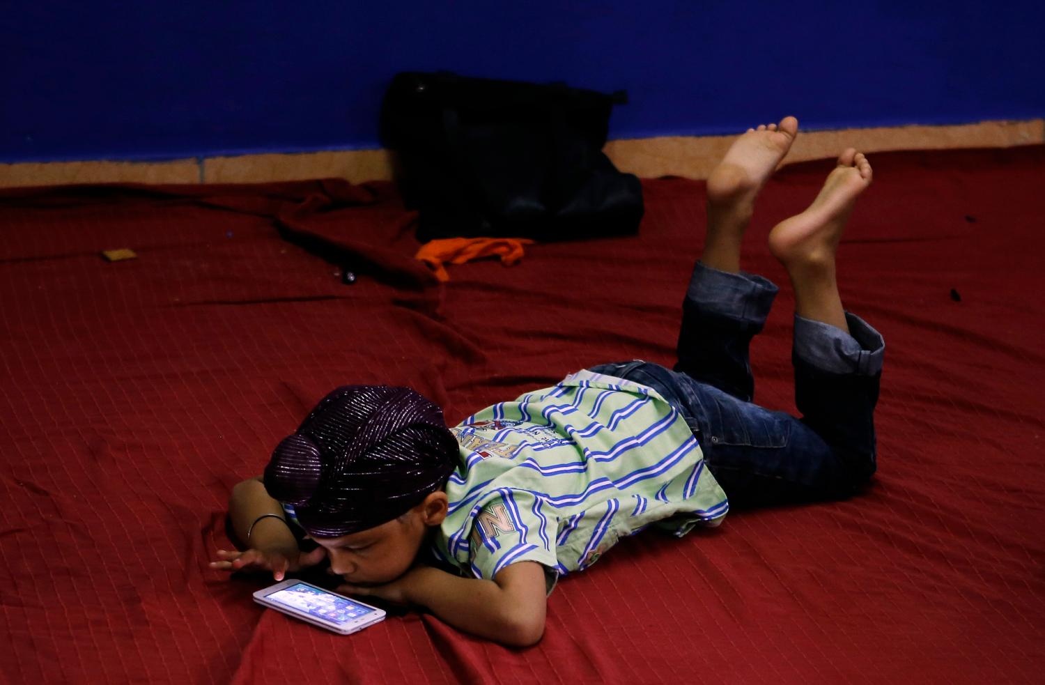 A young child plays with a smartphone