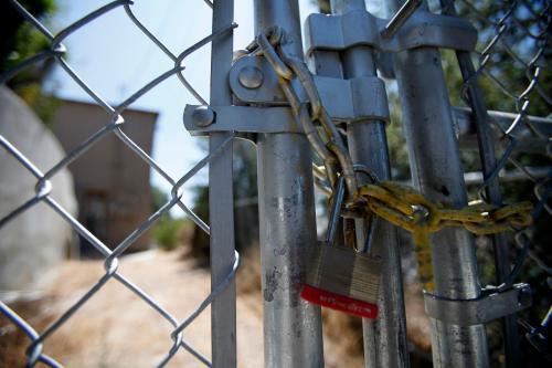 A lock secures a chain on the steel fence of a foreclosed home.