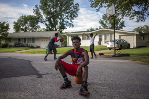 Randy Johnson, 17, a high school student, poses for a portrait between games of basketball outside a friend's residence in Ferguson, Missouri July 21, 2015. When asked how Michael Brown's death affected him, Johnson said, "I don't trust the law anymore. I could be next." When asked what changes he has seen in his community over the past year, Johnson said, "The police don't come around no more. They don't want an incident like that." On August 9, 2014 a white police officer shot unarmed black teenager Michael Brown dead in the St. Louis suburb of Ferguson, Missouri.