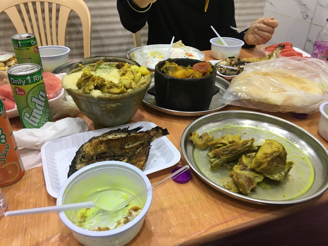 A fantastic lunch of local delights in the small town of Abu Arish outside Jizan. The black stone pot with a spicy fish stew reminded me of Yemeni food. In the bowl next to it is a stew with lamb, beans, and Ethiopian-style injera bread, topped with a strange yeasty foam. Instead of lentil soup (a traditional peninsula starter), we started with an incredibly rich lamb-bone broth.