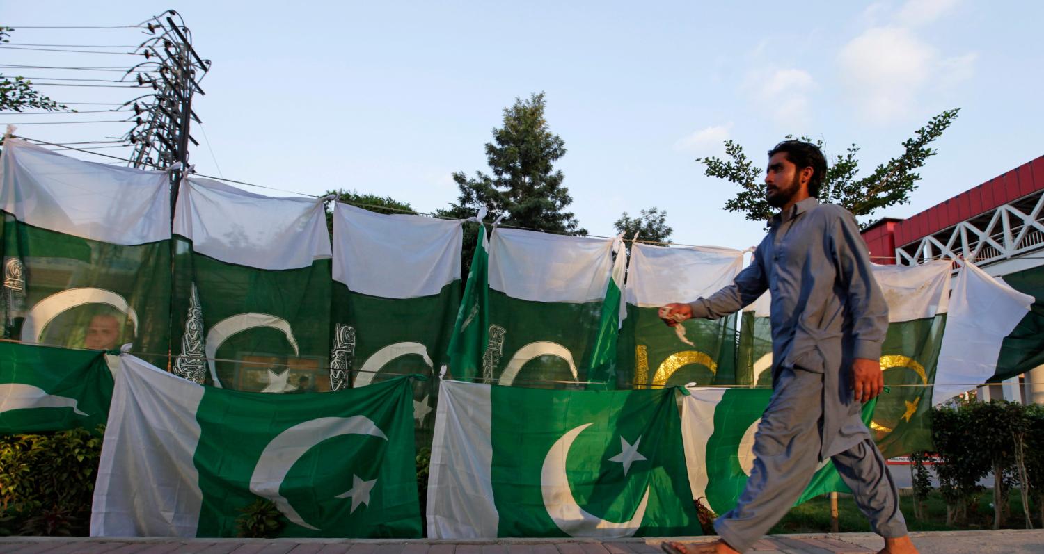 A man walks past a Pakistani flag display along a roadside as people prepare to celebrate the country's upcoming Independence Day in Rawalpindi, Pakistan, August 12, 2016. REUTERS/Faisal Mahmood - S1BETVBTJSAA