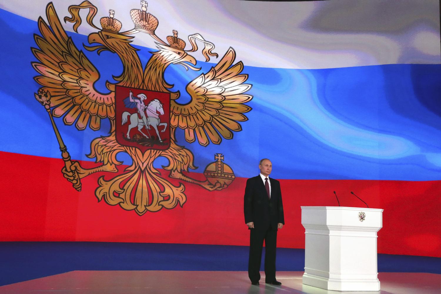 Russian President Vladimir Putin stands on the stage as he addresses the Federal Assembly, including the State Duma parliamentarians, members of the Federation Council, regional governors and other high-ranking officials, in Moscow, Russia March 1, 2018. Sputnik/Mikhail Klimentyev/Kremlin via REUTERS ATTENTION EDITORS - THIS IMAGE WAS PROVIDED BY A THIRD PARTY. - UP1EE310W85R3