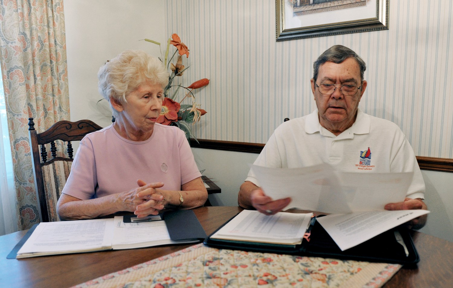 Retired engineer and his wife look over documents concerning their investments at their home in Orlando.