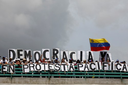 Opposition supporters hold letters forming the slogan "Democracy now in peaceful protest", during a rally against Venezuelan President Nicolas Maduro's government in Caracas