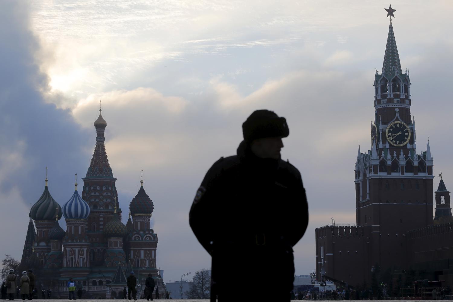 An Interior Ministry member stands guard on Red Square with parts of the Kremlin seen in the background.