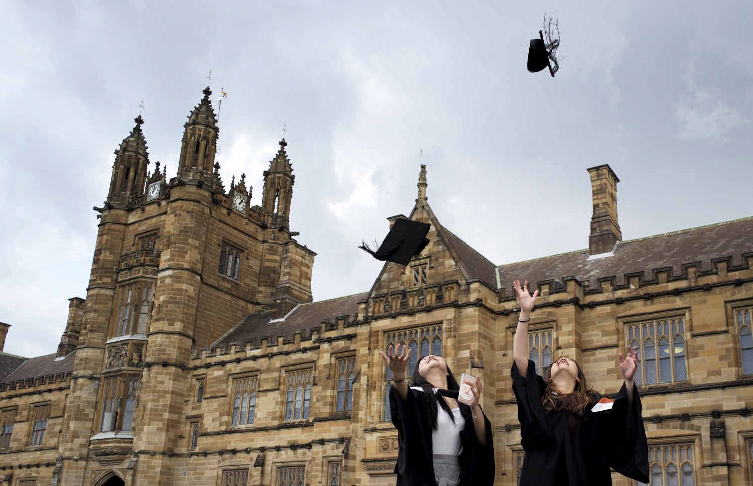 Graduates throw their hats into their air.
