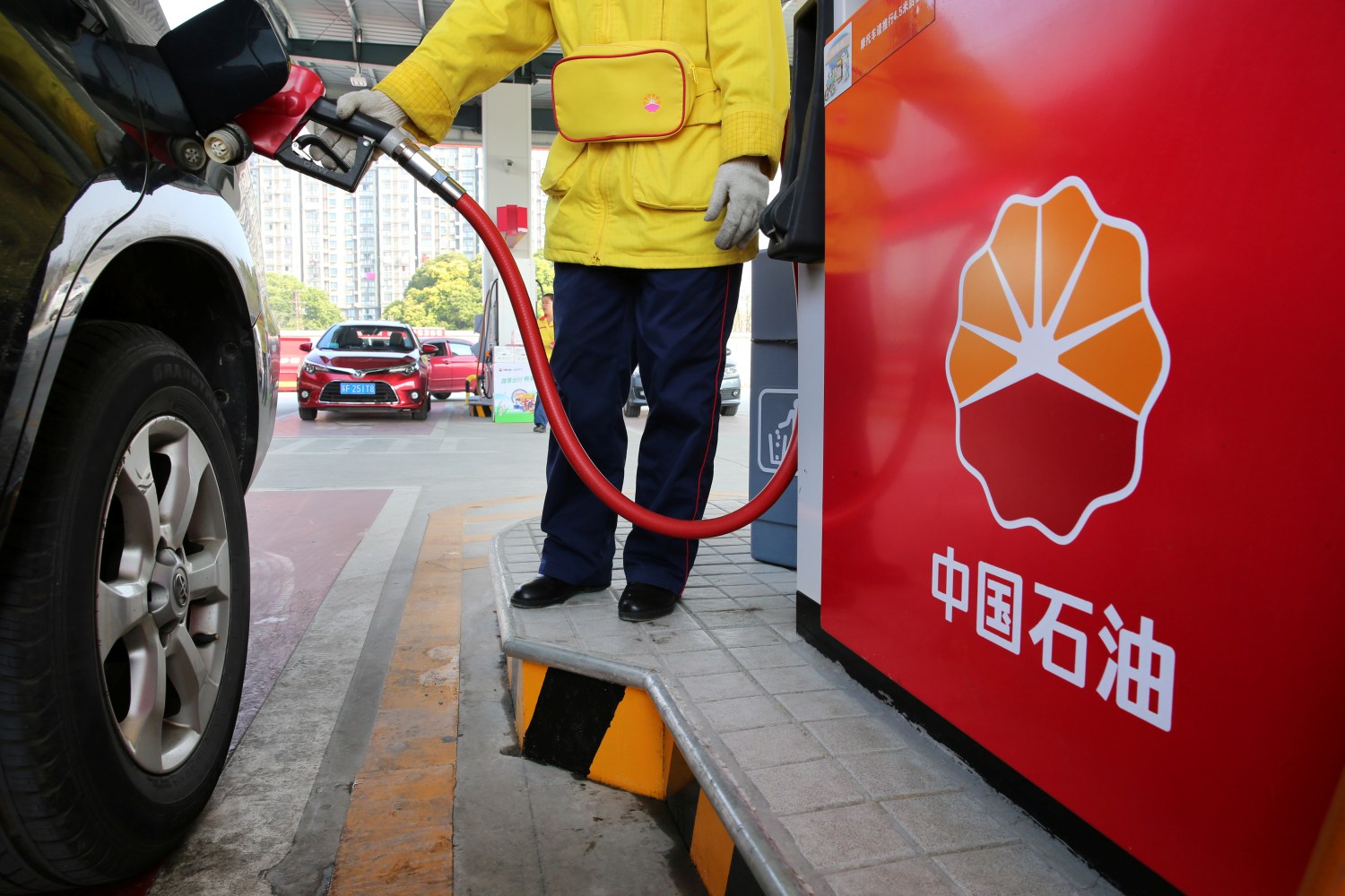 A gas station attendant pumps fuel into a customer's car at PetroChina's petrol station in Nantong, Jiangsu province, China March 28, 2018. Picture taken March 28, 2018. REUTERS/Stringer ATTENTION EDITORS - THIS IMAGE WAS PROVIDED BY A THIRD PARTY. CHINA OUT. - RC1D409DBC40