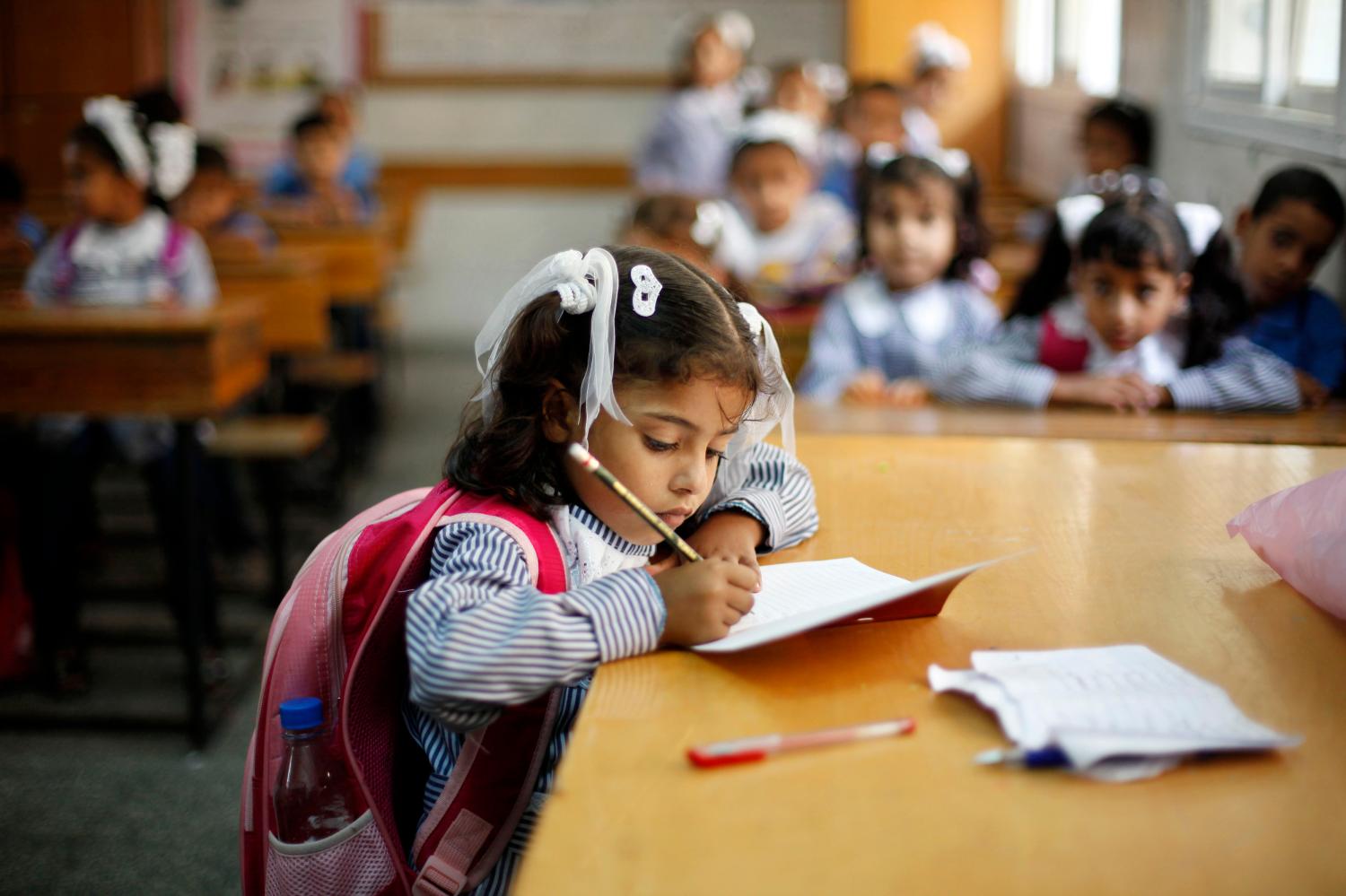 A girl writes during her class