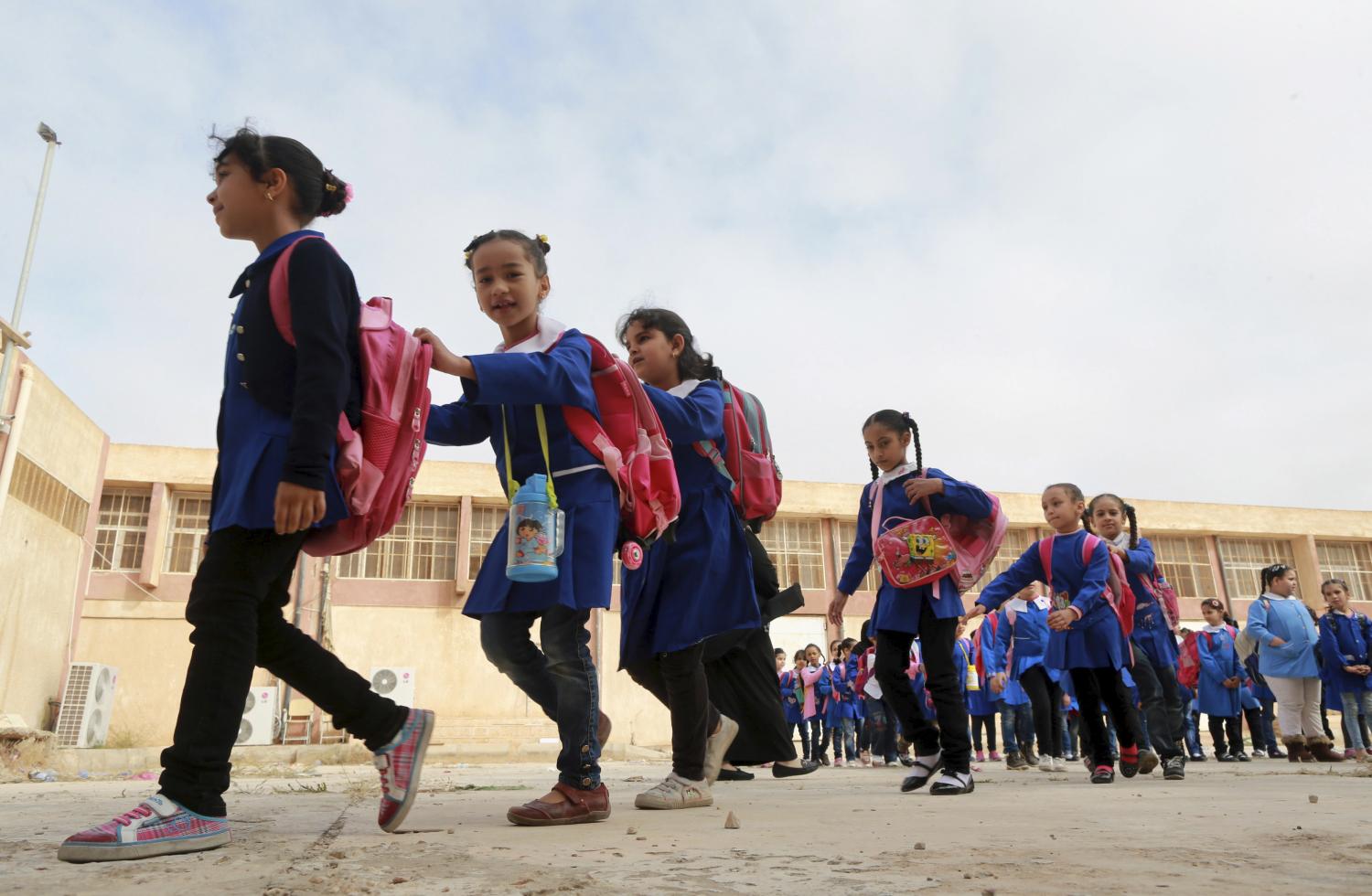 Schoolgirls stand in a queue at a school