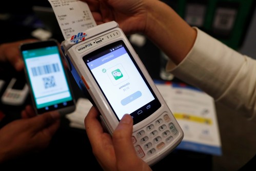 People demonstrate a high security digital unit built by Motion Pay, that allows customers to pay in Chinese yuan renminbi using Chinese online money payment services "WeChat Pay", and "Alipay", where payments get converted to Canadian dollars at point of sales locations in Canadian stores and businesses, in Toronto, Canada, May 24, 2017.