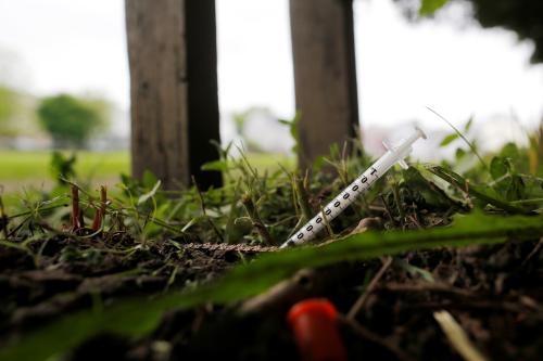 A used needle sits on the ground in a park in Lawrence, Massachusetts, U.S., May 30, 2017, where individuals were arrested earlier in the day during raids to break up heroin and fentanyl drug rings in the region, according to law enforcement officials. REUTERS/Brian Snyder - RC1B1DEBCC10