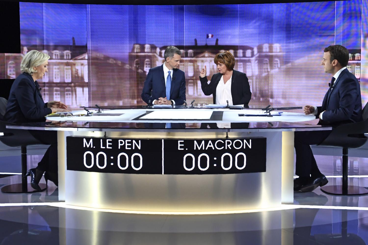 (From L) French presidential election candidate for the far-right Front National (FN) party, Marine Le Pen, French journalist Christophe Jakubyszyn, French journalist Nathalie Saint-Cricq and French presidential election candidate for the En Marche ! or Onwards ! movement, Emmanuel Macron pose prior to the start of a live broadcast face-to-face debate in television studios of French public national television channel France 2, and French private channel TF1 in La Plaine-Saint-Denis, Paris, France, May 3, 2017. REUTERS/Eric Feferberg/Pool - UP1ED531JT6BW