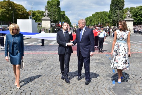 French President Emmanuel Macron (C-L) shakes hands with U.S. President Donald Trump, next to Macron's wife Brigitte Macron (L) and U.S. First Lady Melania Trump during the traditional Bastille Day military parade on the Champs-Elysees avenue in Paris, France, July 14, 2017. REUTERS/Christophe Archambault/Pool - RC127EEC3070