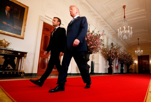 U.S. President Donald Trump (R) and French President Emmanuel Macron walk through the cross hall of the White House as they arrive for their joint news conference in Washington, U.S., April 24, 2018. REUTERS/Kevin Lamarque - HP1EE4O1EPJAX