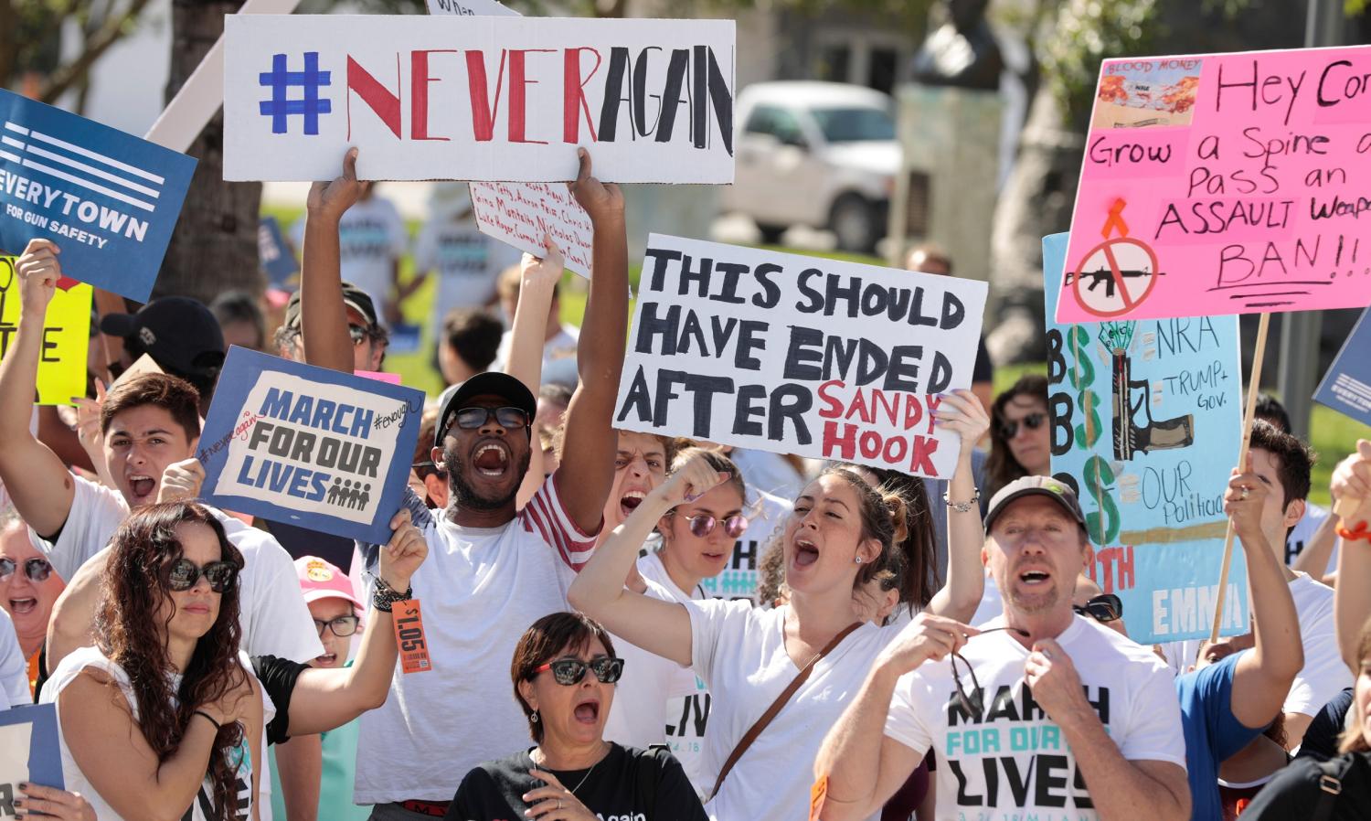 Students hold signs while rallying in the street during the "March for Our Lives" demanding stricter gun control laws at the Miami Beach Senior High School, in Miami, Florida, U.S., March 24, 2018. REUTERS/Javier Galeano - RC1C60279010