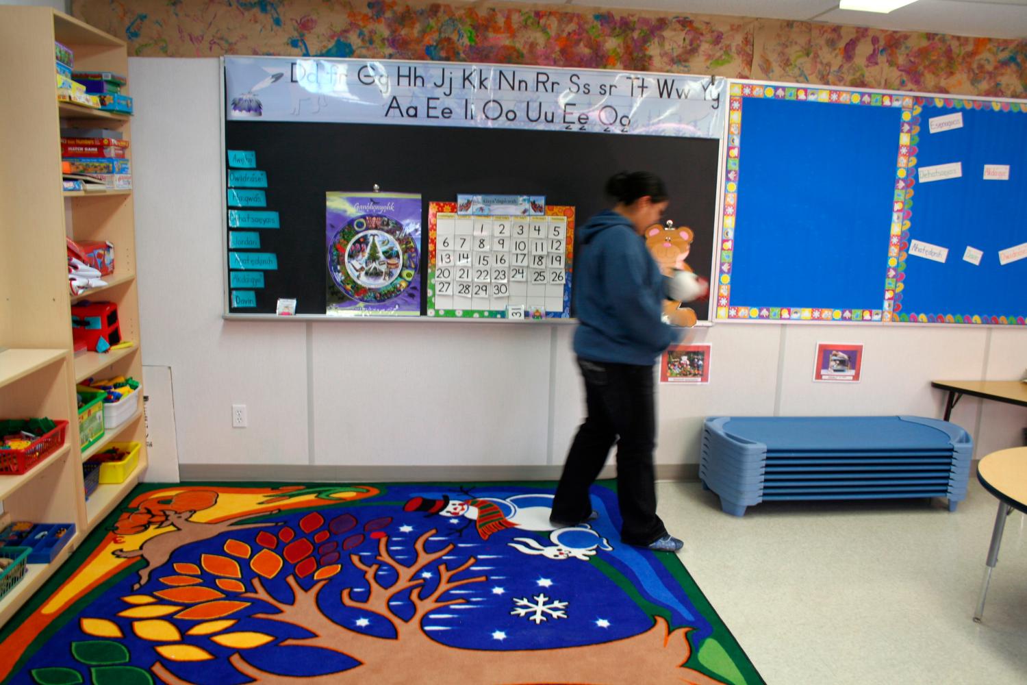 Kindergarten teacher Esenogwas Jacobs tidies her classroom