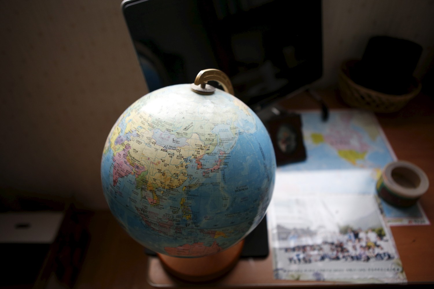 A globe is seen on a desk.