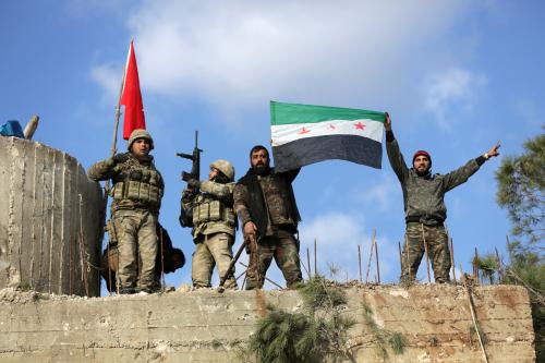 Turkish forces and Free Syrian Army members hold flags on Mount Barsaya, northeast of Afrin, Syria January 28, 2018. REUTERS/ Khalil Ashawi