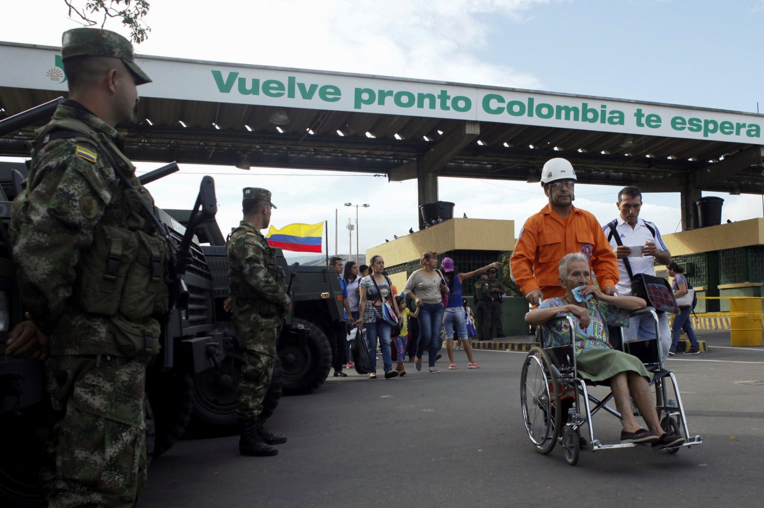 A member of the Colombian civil defense pushes a woman on a wheelchair after she crosses from Venezuela over the Simon Bolivar international bridge.
