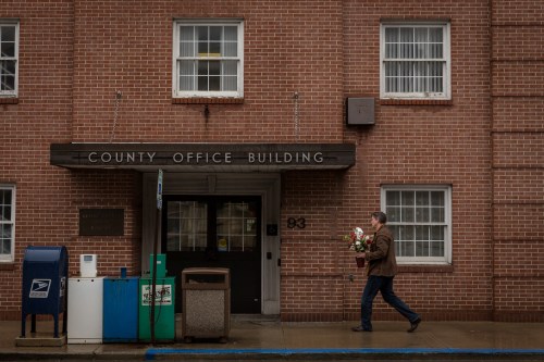 A man carries flowers outside a county office on Valentine's Day in Waynesburg, Pennsylvania, U.S., February 14, 2018. Picture taken February 14, 2018. REUTERS/Maranie Staab - RC164B0CD210