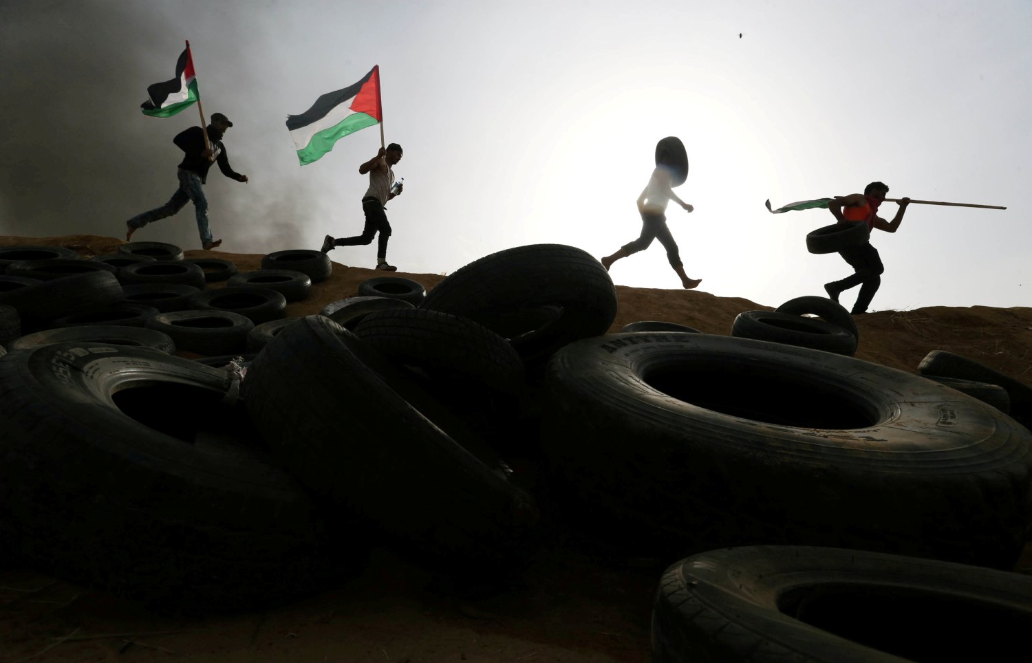 Palestinian protesters run during clashes with Israeli troops at Israel-Gaza border, in the southern Gaza Strip April 5, 2018. REUTERS/Ibraheem Abu Mustafa