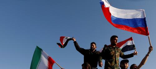 Syrians wave Iranian, Russian and Syrian flags during a protest against U.S.-led air strikes in Damascus,Syria April 14,2018.REUTERS/ Omar Sanadiki TPX IMAGES OF THE DAY - RC1815671B90