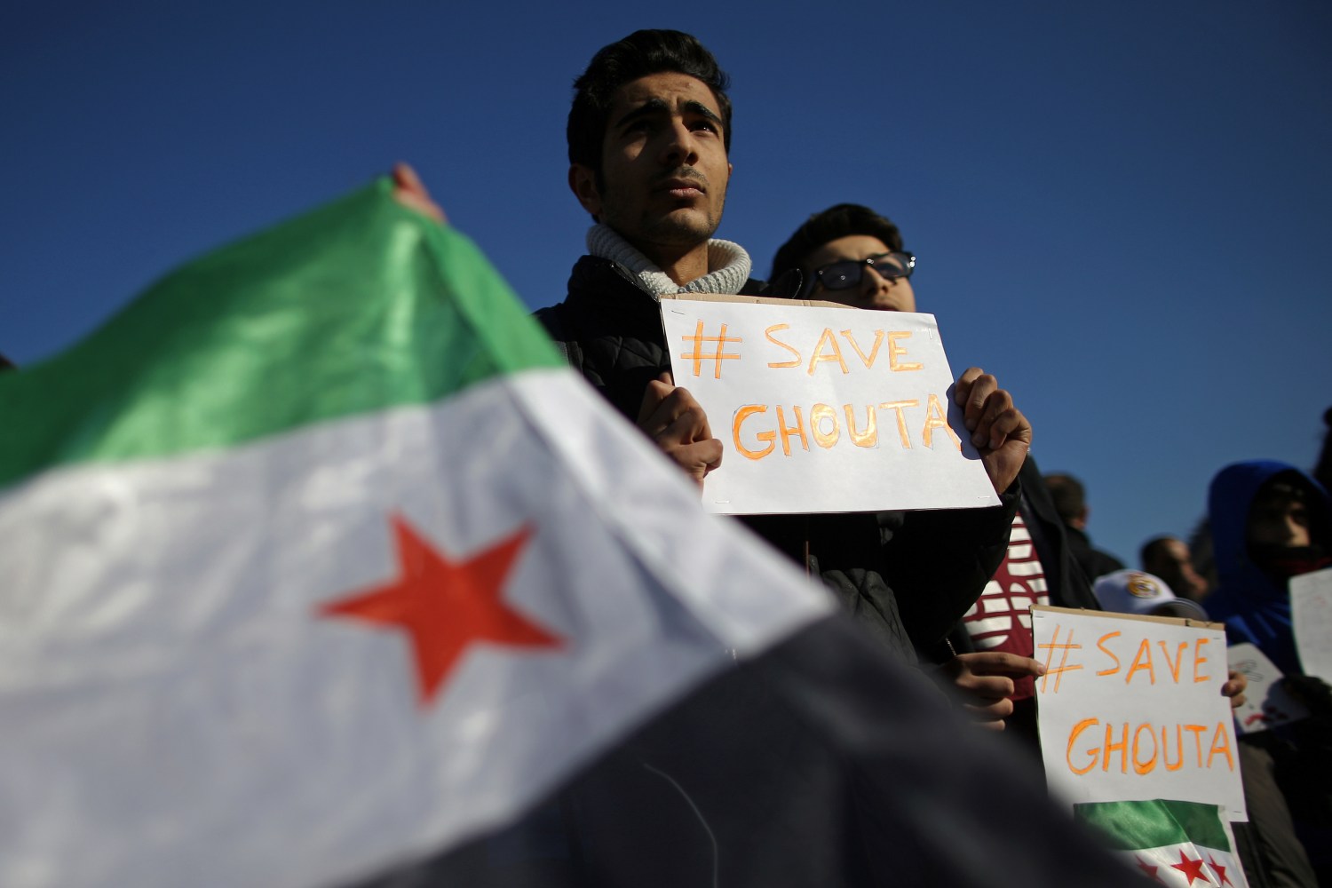 A demonstrator holds a placard during a protest for solidarity with Syria, in Paris