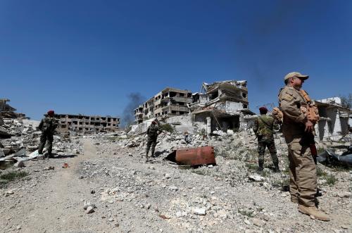 Members of Syrian forces of President Bashar al Assad stand guard near destroyed buildings in Jobar, eastern Ghouta, in Damascus, Syria April 2, 2018. REUTERS/Omar Sanadiki - RC1C4E863200
