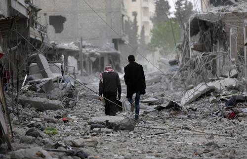 Men walk through debris in the center of Afrin, Syria March 24, 2018. REUTERS/Khalil Ashawi - RC1850B1E4F0