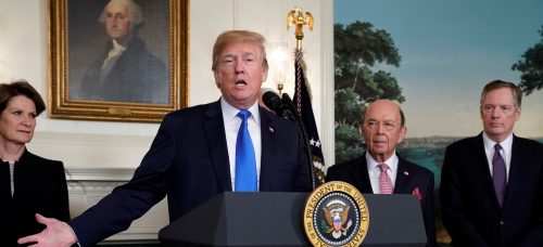 U.S. President Donald Trump, flanked by Lockheed Martin CEO Marillyn Hewson (L), Commerce Secretary Wilbur Ross (2nd R) and U.S. Trade Representative Robert Lighthizer (R), delivers remarks before signing a memorandum on intellectual property tariffs on high-tech goods from China, at the White House in Washington, U.S. March 22, 2018. REUTERS/Jonathan Ernst - RC145E32B800