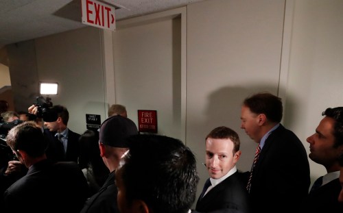 Members of the media (L) keep pace with Facebook CEO Mark Zuckerberg