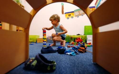 A four year-old boy plays with building blocks