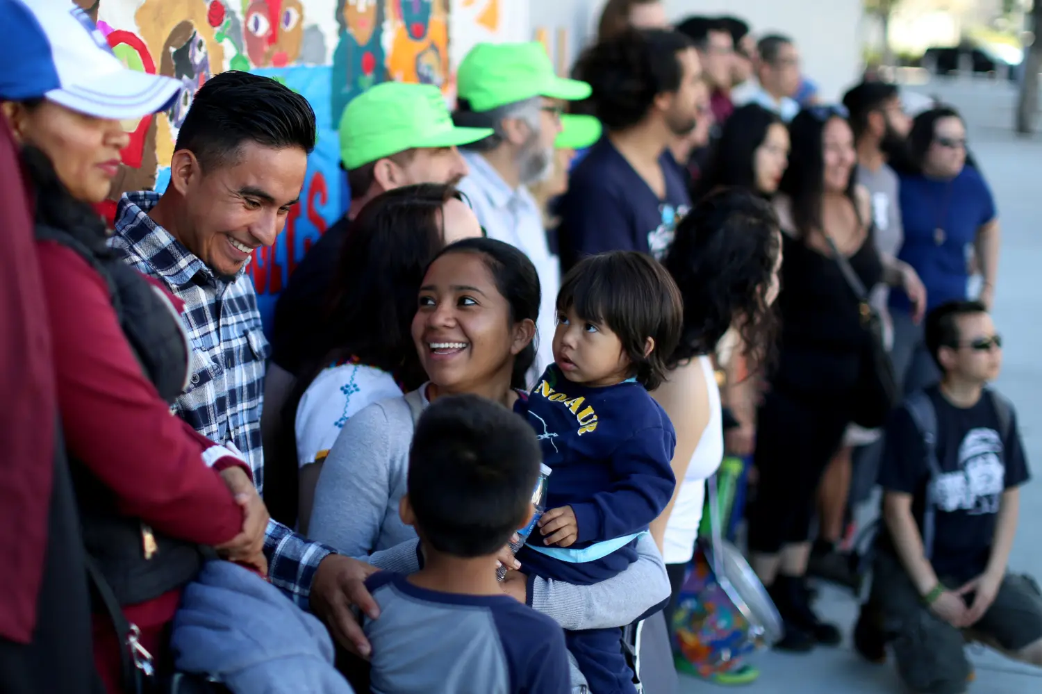 Olivia Caceras holds one of her children as she and other marchers prepare to start a 140-mile walk to the Mexican border, in solidarity with hundreds of hopeful asylum seekers who are currently traveling northbound in a caravan through Mexico, from central Los Angeles, California, U.S. April 22, 2018.  REUTERS/David McNew - RC1E7A36A840