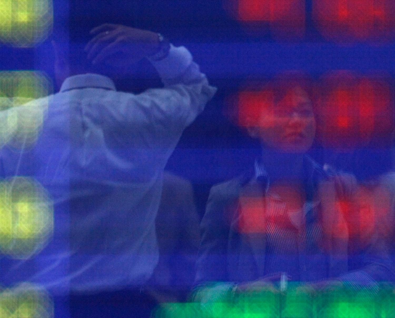 Pedestrians are reflected in a screen displaying stock market data in downtown Tokyo May 7, 2010. Asian stocks were hammered on Friday as mounting fears over Europe's debt crisis sparked a global market rout that sent safe-haven assets soaring and clobbered sterling. REUTERS/Michael Caronna (JAPAN - Tags: EMPLOYMENT BUSINESS) - GM1E65716PD01