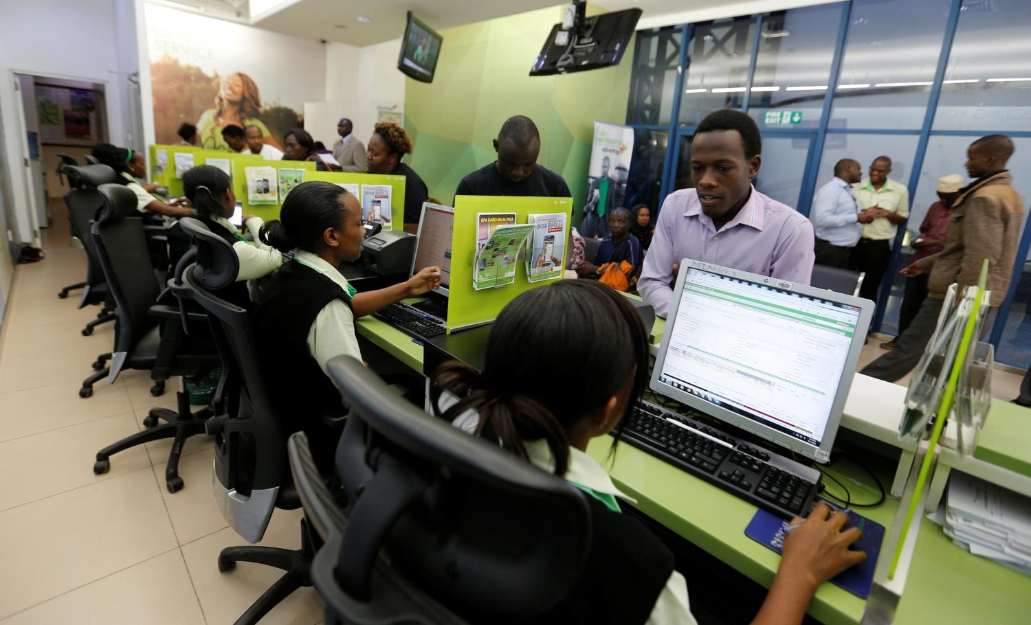 Employees serve customers inside a mobile phone care centre operated by Kenyan's telecom operator Safaricom in the central business district of Kenya's capital Nairobi, May 11, 2016. REUTERS/Thomas Mukoya - D1AETDLLWWAA