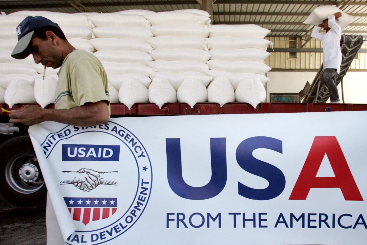 Workers load humanitarian aid onto a truck before it is sent to Lebanon from Amman, Jordan August 31, 2006. The United States, through the Agency for International Developments (USAID), donated 700 metric tons of wheat to the World Food Program for immediate release and transport to Lebanon, according to the U.S. embassy in Amman. REUTERS/Muhammad Hamed  (JORDAN) - GM1DTJYEBNAA