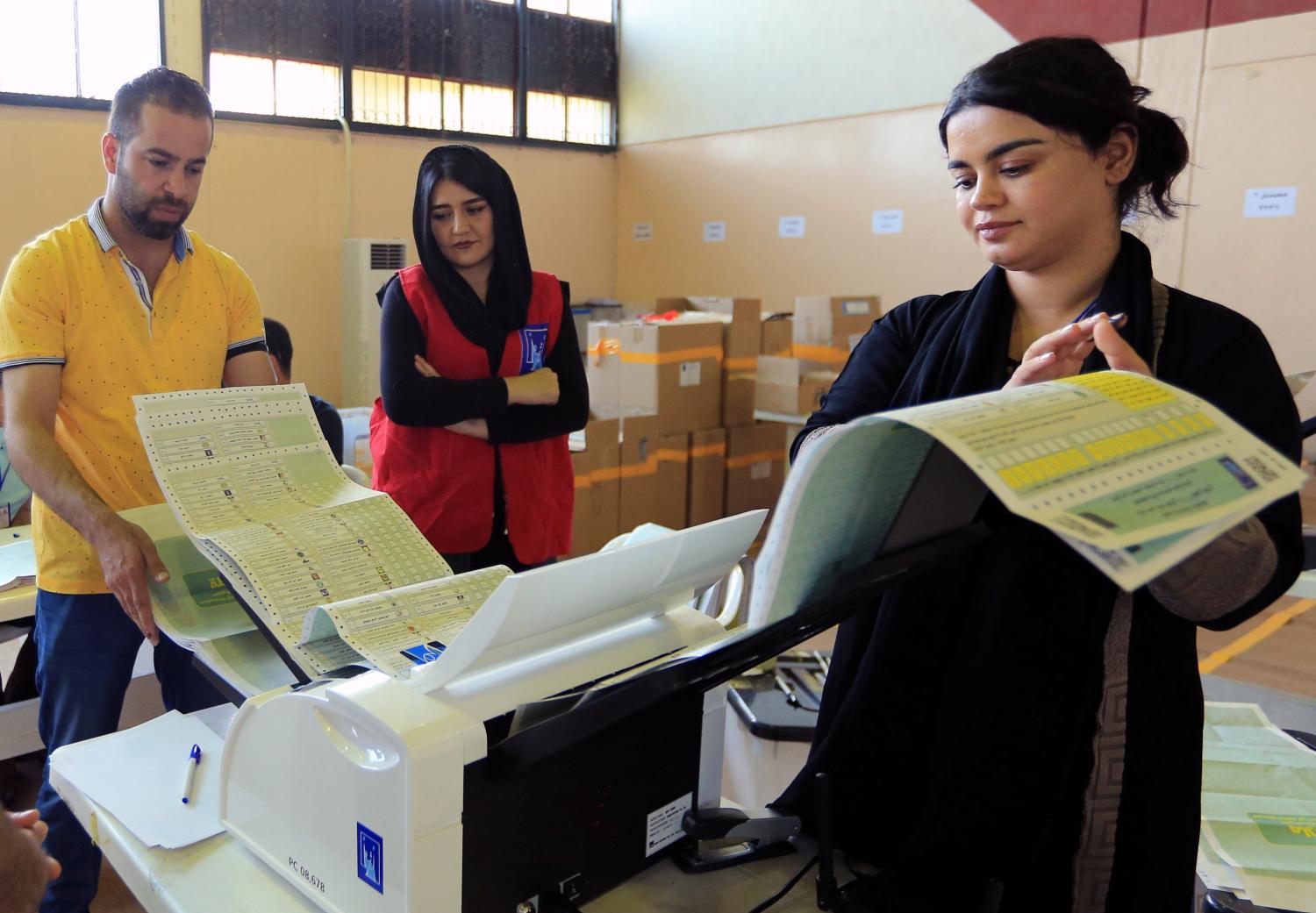 Employees of the Iraqi Independent High Electoral Commission check electronic counting device at a warehouse in Dohuk, Iraq May 16, 2018. REUTERS/Ari Jalal - RC1B40CD3970