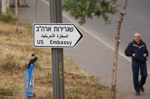 A man walks next to a road sign directing to the U.S. embassy, in the area of the U.S. consulate in Jerusalem, May 7, 2018. REUTERS/Ronen Zvulun - RC14A19DFCA0