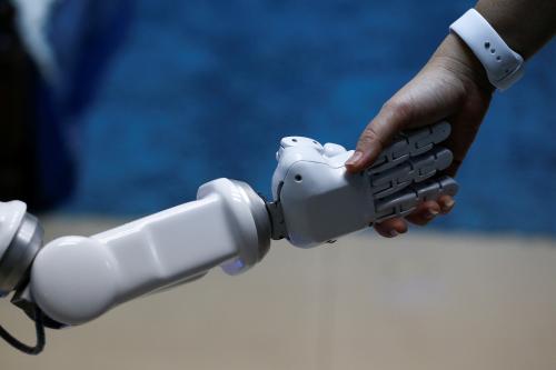 Chalermpon Punnotok, CEO of CT Asia Robotics gives a hand to a robot during an interview with Reuters in Bangkok, Thailand July 5, 2016. Picture taken July 5, 2016. REUTERS/Athit Perawongmetha - RTX2L2XB