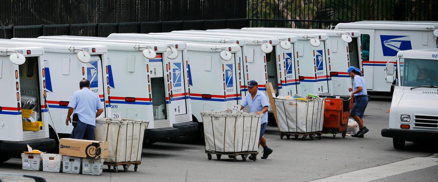 U.S. postal workers load their trucks with mail for delivery from their postal station in Carlsbad, California February 6, 2013. The Postal Service plans to drop Saturday delivery of first-class mail by August in its latest effort to cut costs after losing nearly $16 billion last fiscal year, the cash-strapped mail agency said on Wednesday. REUTERS/Mike Blake (UNITED STATES - Tags: BUSINESS EMPLOYMENT POLITICS) - GM1E92708HM01