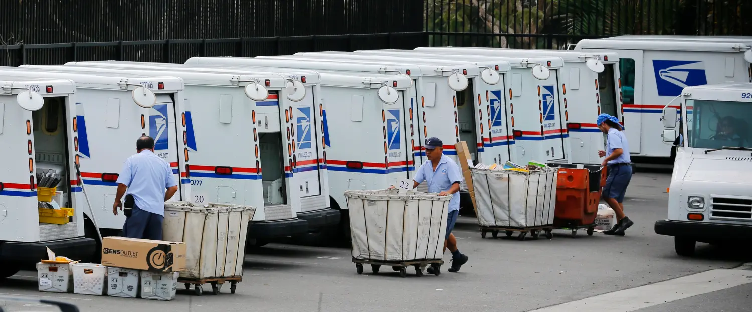 U.S. postal workers load their trucks with mail for delivery from their postal station in Carlsbad, California February 6, 2013. The Postal Service plans to drop Saturday delivery of first-class mail by August in its latest effort to cut costs after losing nearly $16 billion last fiscal year, the cash-strapped mail agency said on Wednesday. REUTERS/Mike Blake (UNITED STATES - Tags: BUSINESS EMPLOYMENT POLITICS) - GM1E92708HM01