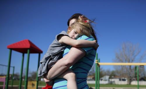A young woman holds her daughter at a playground in Winthrop Harbor, Illinois.