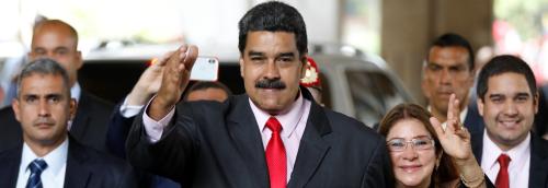 Venezuela's re-elected President Nicolas Maduro greats to supporters next to his wife Cilia Flores as he leaves after receiving a certificate confirming him as winner of Sunday's election at the National Electoral Council (CNE) in Caracas, Venezuela May 22, 2018. REUTERS/Carlos Garcia Rawlins - RC1A504B6CA0