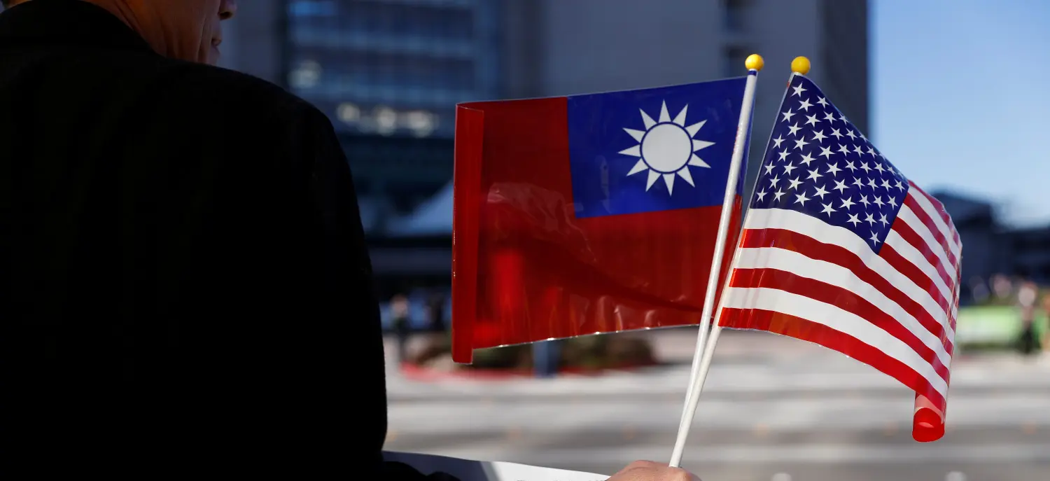 A demonstrator holds flags of Taiwan and the United States in support of Taiwanese President Tsai Ing-wen during an stop-over after her visit to Latin America in Burlingame, California, U.S., January 14, 2017. REUTERS/Stephen Lam